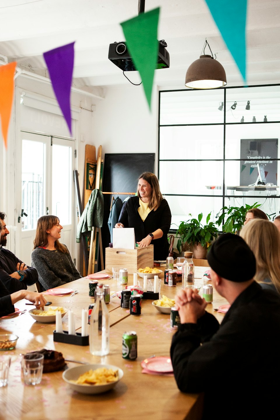 Diverse professionals meeting around a table with food and drinks.